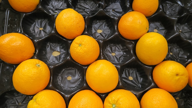 写真 トレイに入れられた新鮮なオレンジのトップビューテクスチャ
