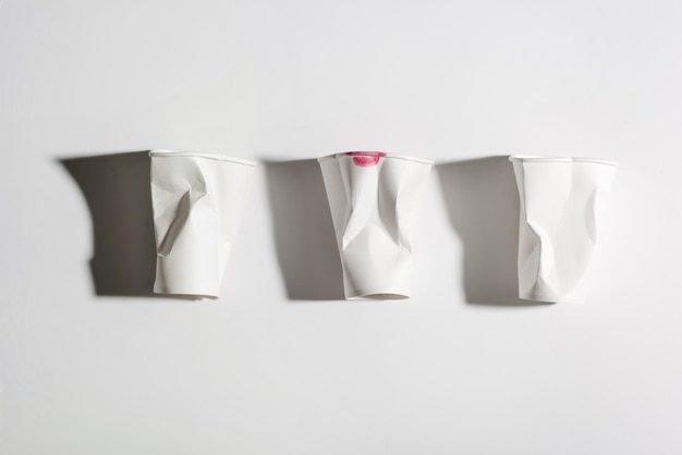 Top view of three crumpled used paper cups isolated on white