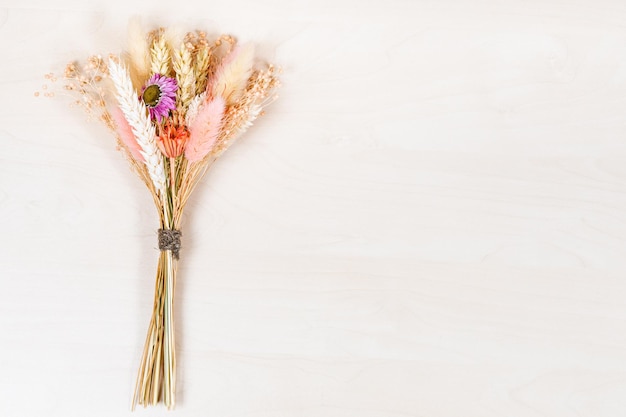 Top view of tied bouquet of dried plants on board