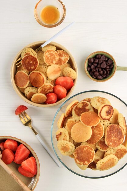 Top View Tiny Pancake Cereal with Strawberries on a  Cream Bowl White Background. Trendy food in 2020 with Copy Space