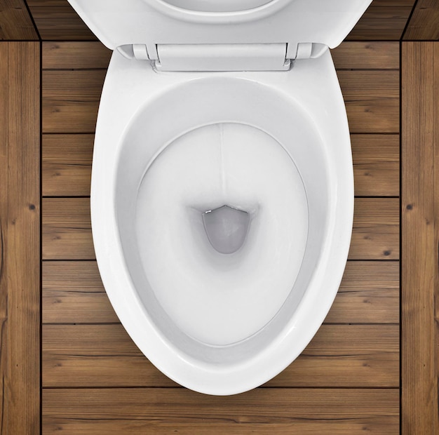 Photo top view of toilet bowl in bathroom with wooden floor