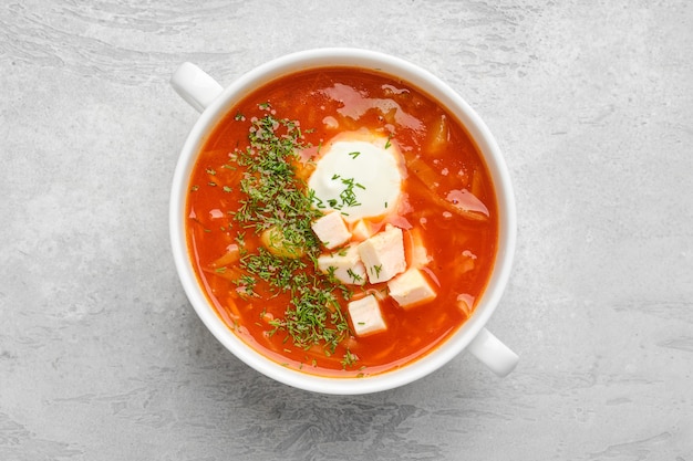 Top view of tomato soup with chicken meat and sour cream