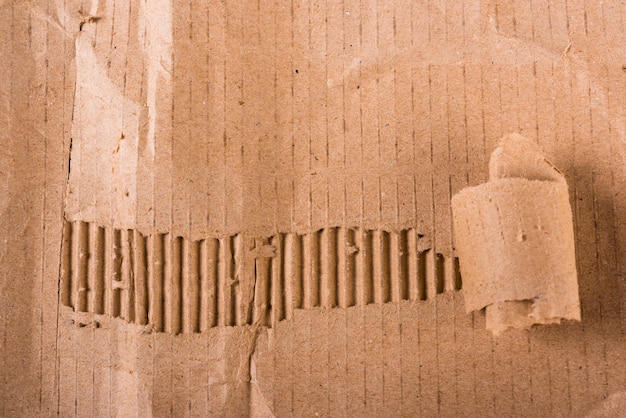 Top view of torn edges corrugated brown cardboard sheet of paper texture or background