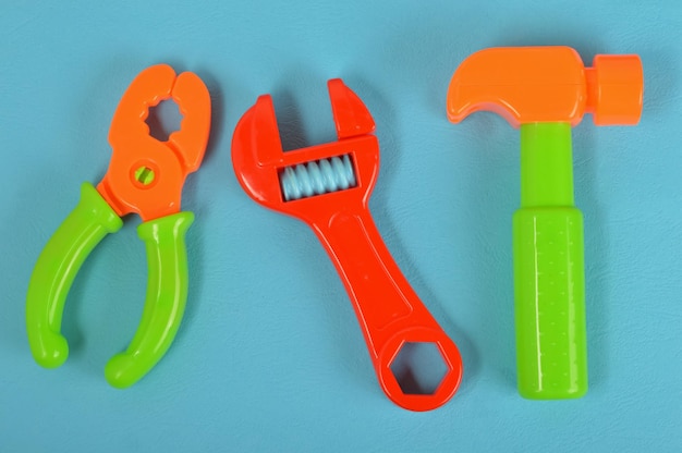 Top view of toy hammer wrench and pliers isolated on a blue background