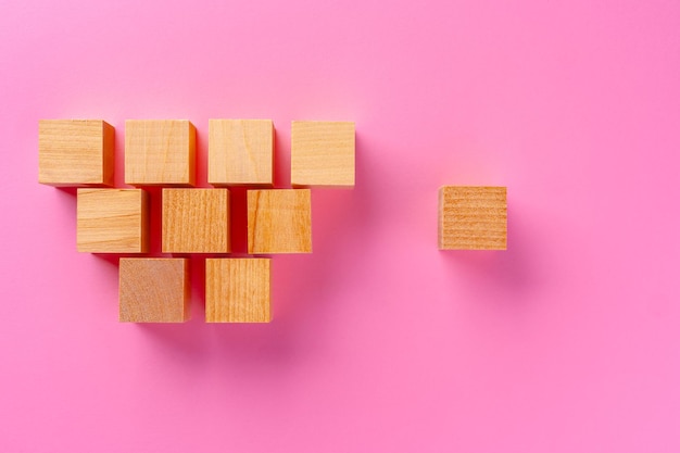 Top view of toy wooden blocks on pink