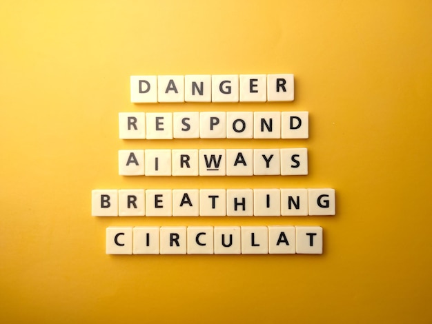 Top view toys letters with the word DANGER RESPOND AIRWAYS BREATHING CIRCULAT