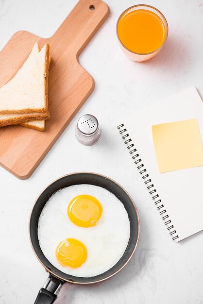 Top view of traditional healthy easy quick breakfast meal made of fried eggs served on a frying pan.