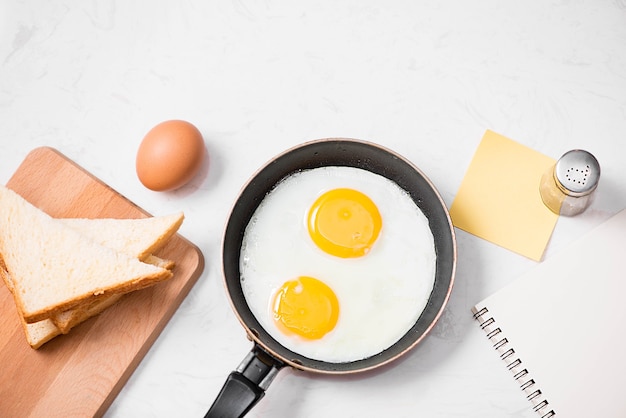 Top view of traditional healthy easy quick breakfast meal made of fried eggs served on a frying pan.