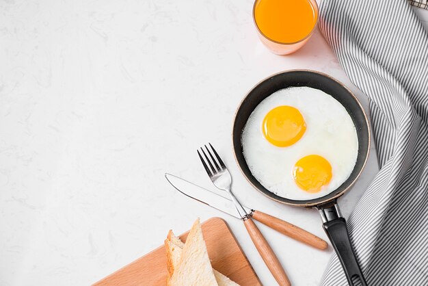 Top view of traditional healthy easy quick breakfast meal made of fried eggs served on a frying pan.