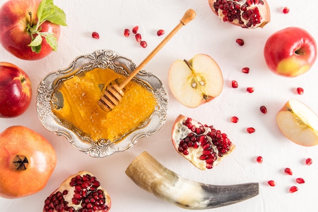 The top view of the traditional symbols of the celebration of the Roshashana honey ripe apples pomegranates and a cornucopia