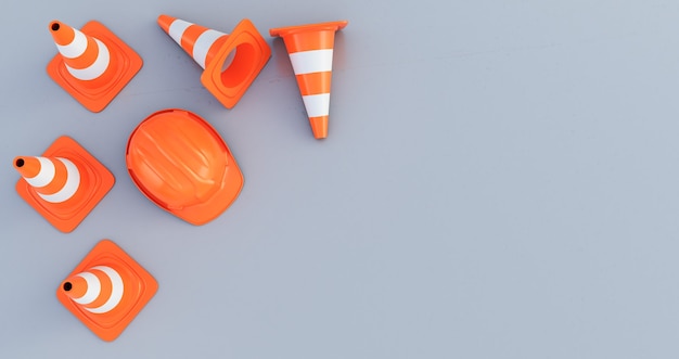 灰色の背景で隔離の上面図のトラフィックコーンとオレンジ色のヘルメット