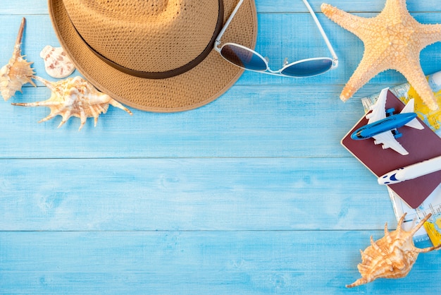 top view of travel accessories on light blue wood plank floor for summer vacation time