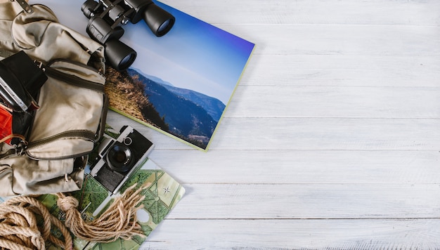 Photo top view of travel accessories for a mountain trip on white wooden