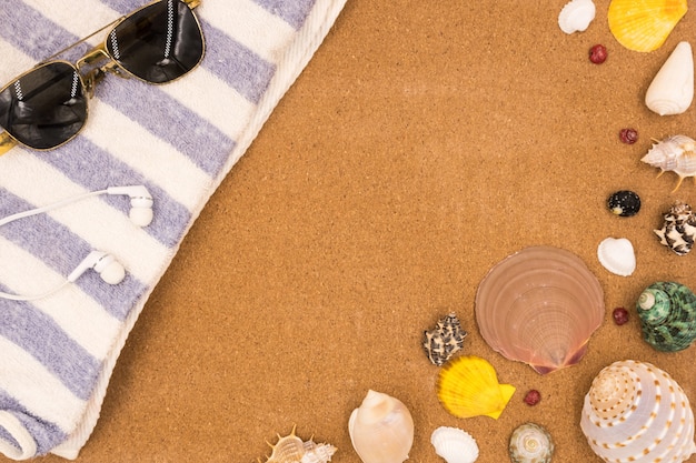 Top view of Travel accessories and Seashells on brown board background.