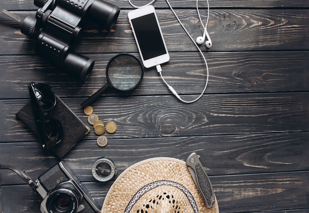 Top view of travel accessories set on wooden background with copy space