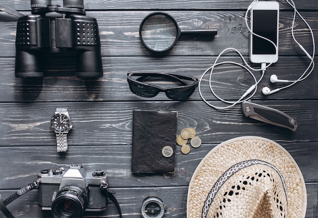 Top view of travel accessories set on wooden background with copy space