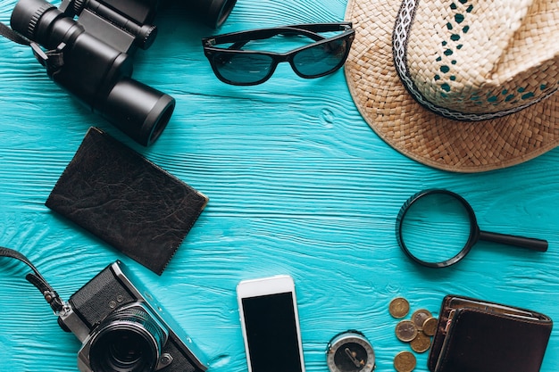 Top view of travel accessories set on wooden blue  background with copy space