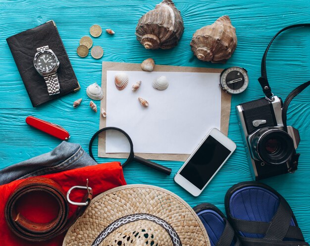 Top view of travel accessories set on wooden blue background with copy space