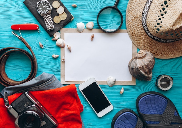 Top view of travel accessories set on wooden blue background with copy space