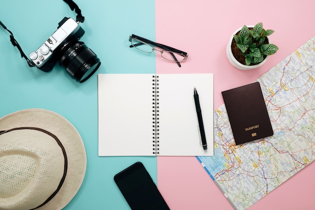 Top view of travel accessories,Traveler concept background with blank notebook and camera on pastel paper.