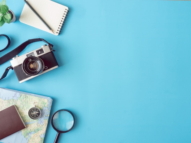 Foto vista dall'alto concetto di viaggio con pellicole per fotocamere retrò, mappa, passaporto e bussola su sfondo blu con spazio di copia, elementi essenziali per il turismo, effetto tono vintage