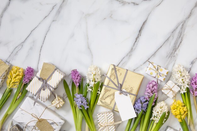 Composizione alla moda vista dall'alto con fiocco di nastro di scatole regalo avvolto festivo decorato da fiori sbocciano