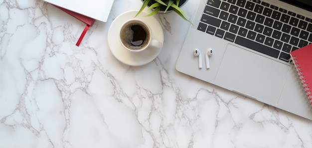 Top view of trendy workspace with laptop computer and coffee cup on marble table background