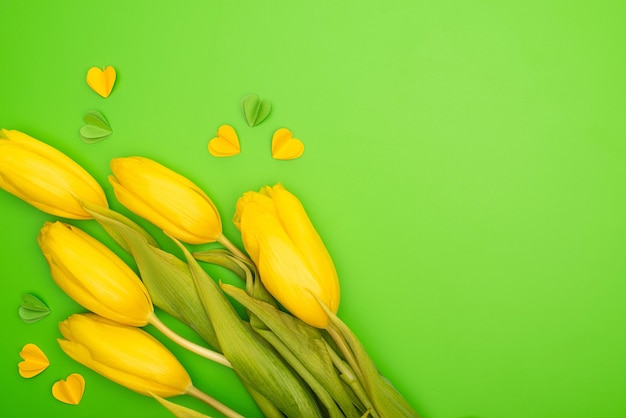 Top view of tulips and colorful decorative hearts on green spring concept