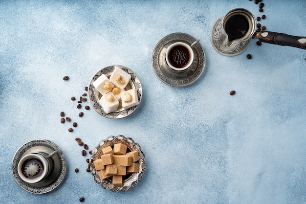 Top view of turkish delight and brown cubed sugar in oriental dishware on table