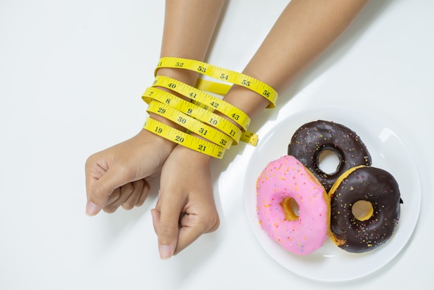 Top view of  two hands of young woman been tied by measuring tape.