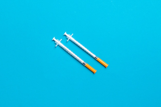 Top view of two insulin syringe at colorful