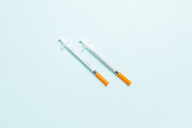 Top view of two insulin syringe at colorful