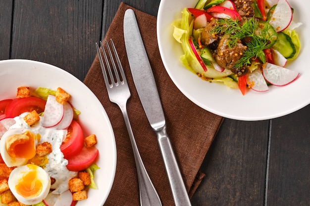 Top view of two plates with salad with fresh vegetables