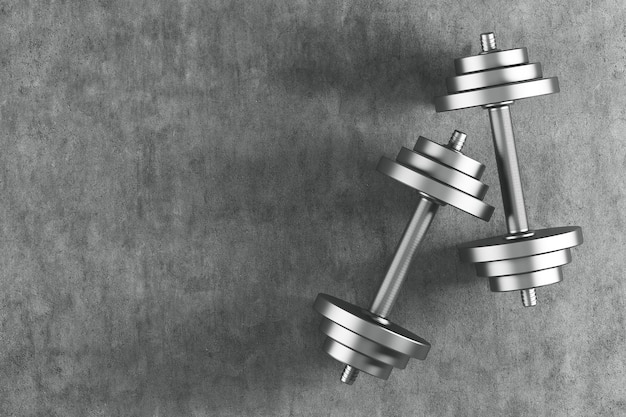 Top view of two shiny steel dumbbells lying on a concrete floor. They are casting shadows. Concept of a healthy lifestyle. 3d rendering mock up