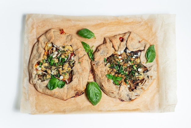 Top view of two vegan galettes on parchment paper White background Homemade food