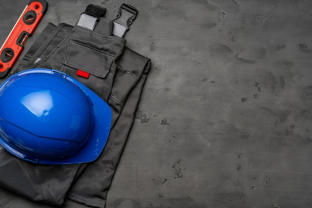 Top view of uniform of construction worker on wooden background