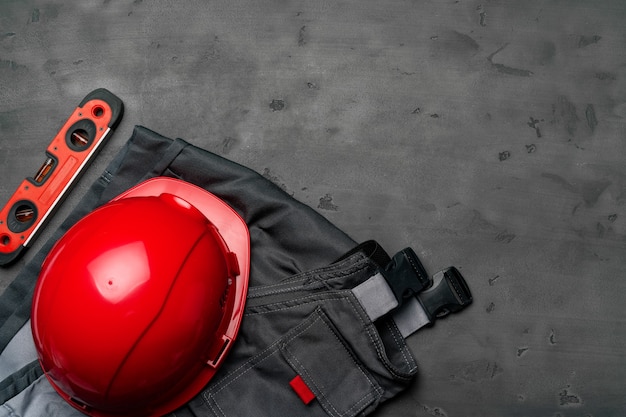 Top view of uniform of construction worker on wooden background