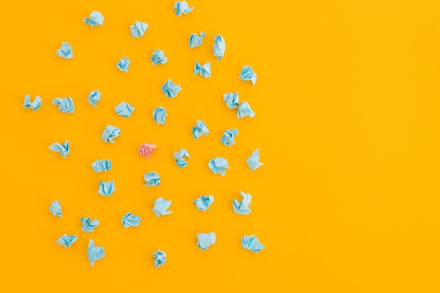 Top view of unique crumpled yellow paper among blue on yellow background New idea In search