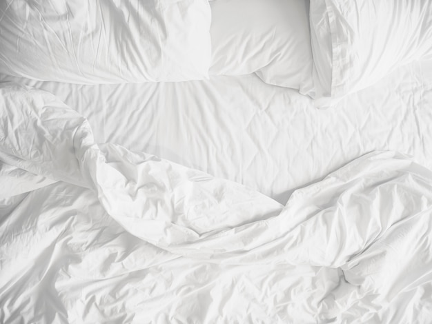 Top view of unmade bedding sheets and pillow 