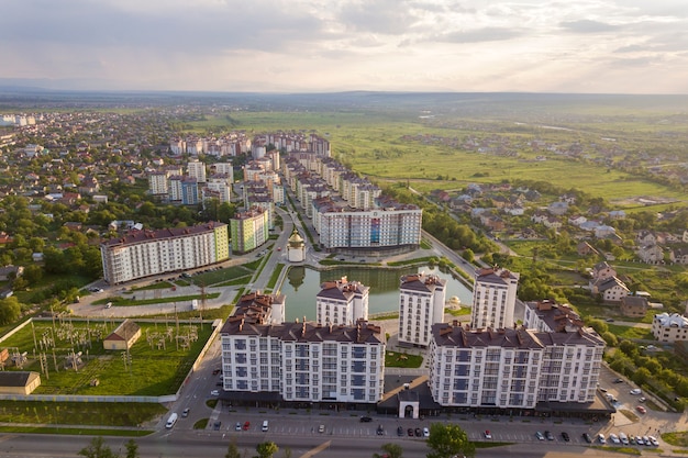 Взгляд сверху городского развивающего ландшафта города с высокорослыми жилыми домами и домами пригорода.