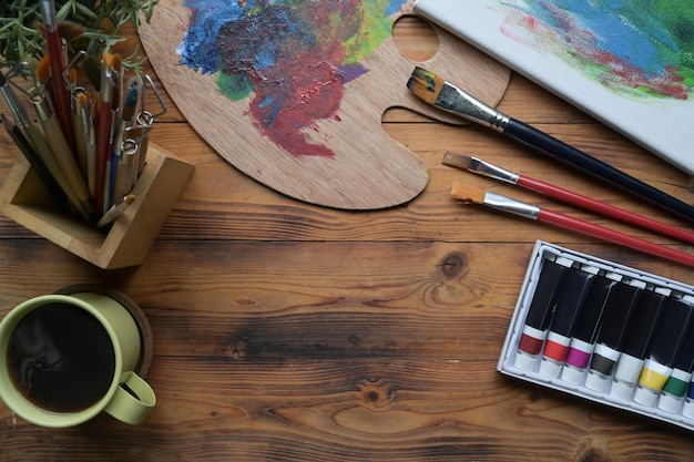 照片顶视图木桌子上用画笔和调色板