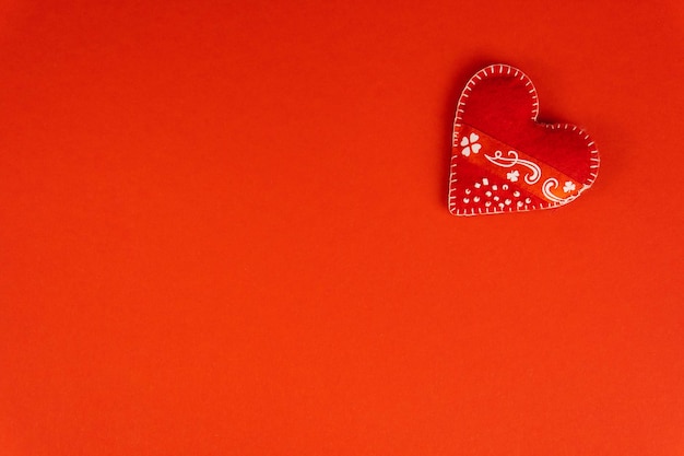 Top view Valentines Day concept with copy space Red textile heart on red papper background