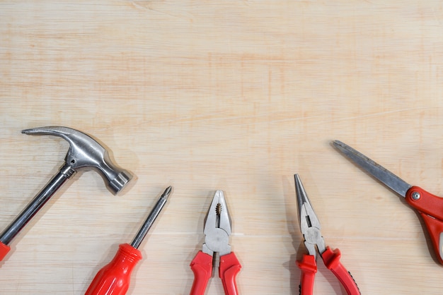 Top view of variety handy tools on wooden board background for Labor day.