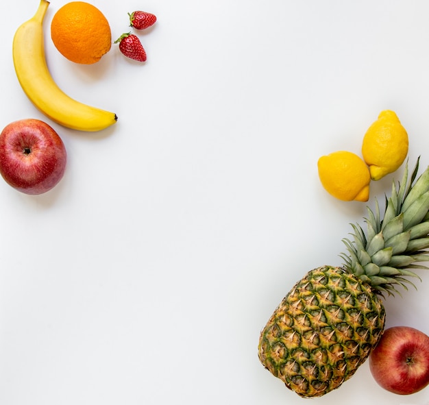 Top view of various fruits on white. Copy space.