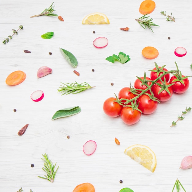 top view of various types of aromatic herb leaves and cut vegetables on wooden background