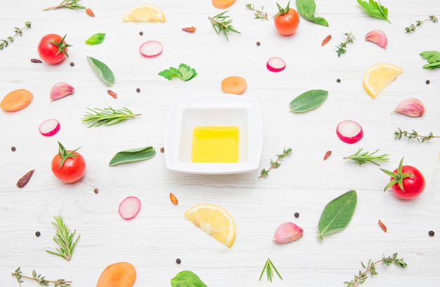 Top view of various types of aromatic herb leaves and cut vegetables on wooden table