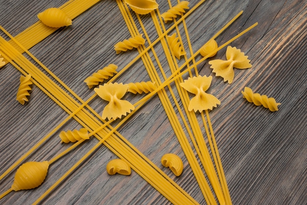 Photo top view various types of italian pasta on wooden background