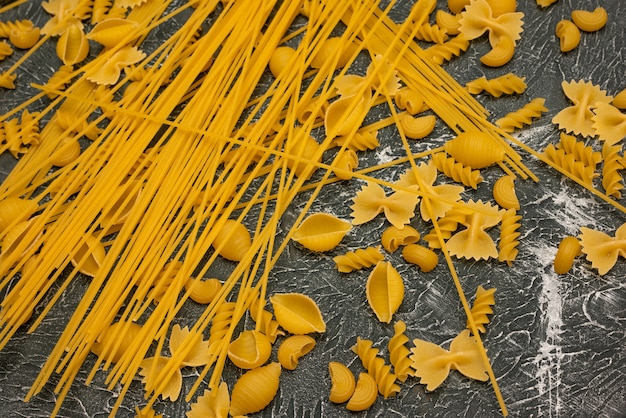 Top view Various types of Italian pasta on wooden background