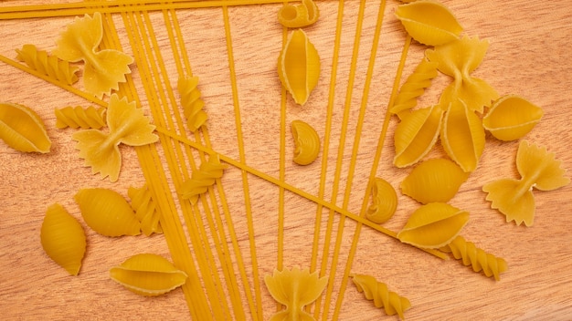 Top view Various types of Italian pasta on wooden background