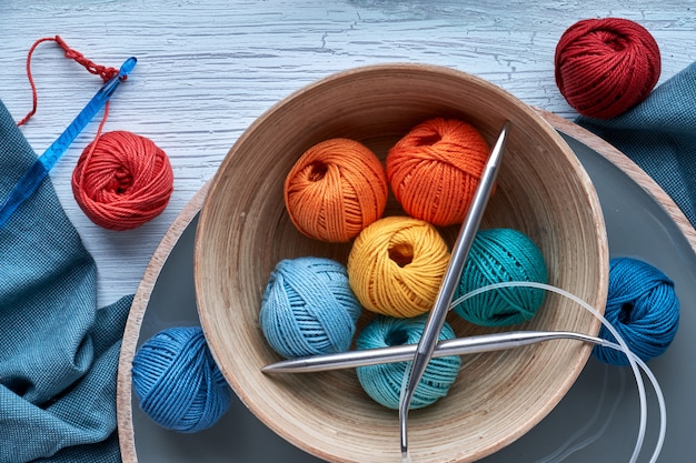 Top view of various yarn balls and latch hook on textured